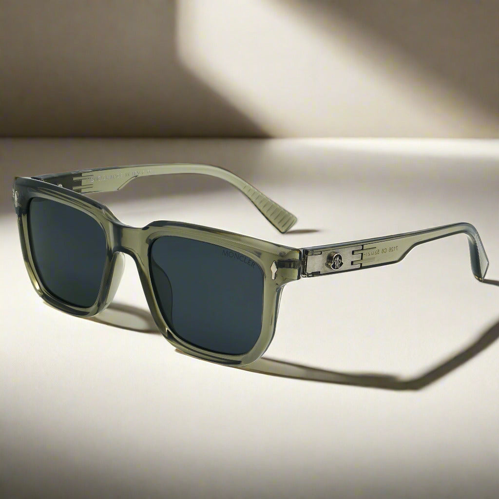 A pair of Moncler polarized sunglasses with green frames and dark lenses, displayed on a surface.