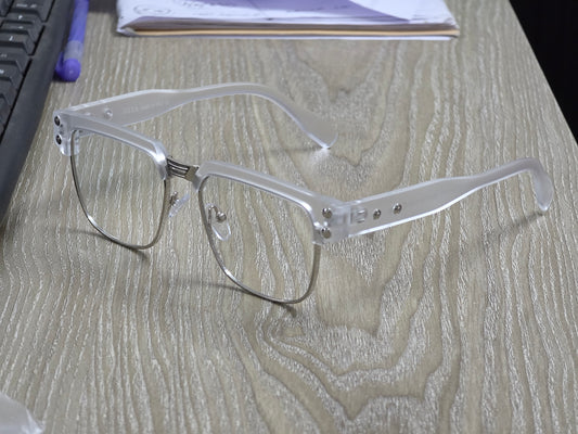 Clear eyeglasses on a wooden surface with a blurred background