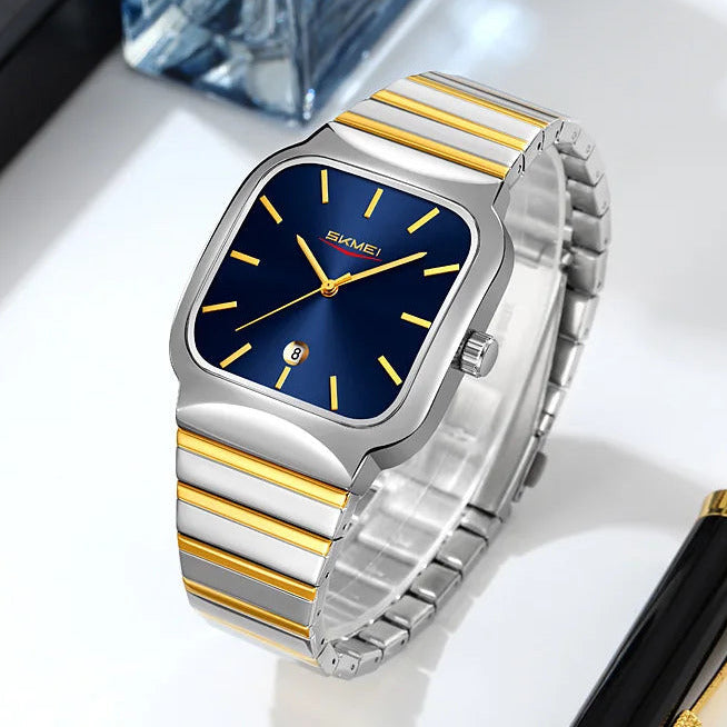Luxury watch with blue face and gold accents on a white surface with a pen and water bottle in the background.