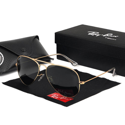A pair of Rayban aviator sunglasses with a golden frame and black lenses, displayed next to an open box with the Rayban logo inside.