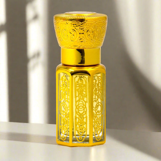 Gold-colored perfume bottle with intricate designs on a white background