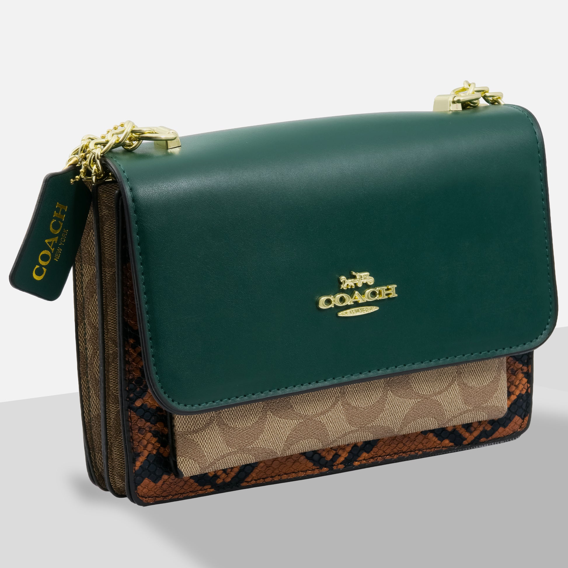 Green Coach handbag with patterned flap on a light gray background