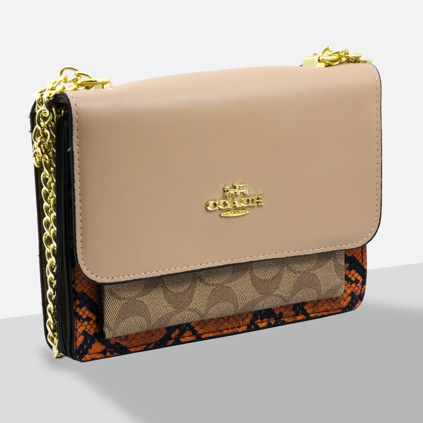 Beige handbag with gold chain strap and Coach logo on a light gray background