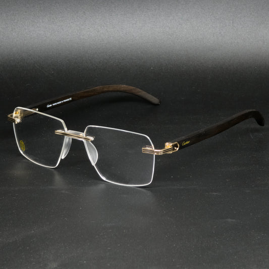 A pair of rimless eyeglasses with a dark brown wood-look frame, gold metal hinges, and clear lenses, displayed on a dark gray background.