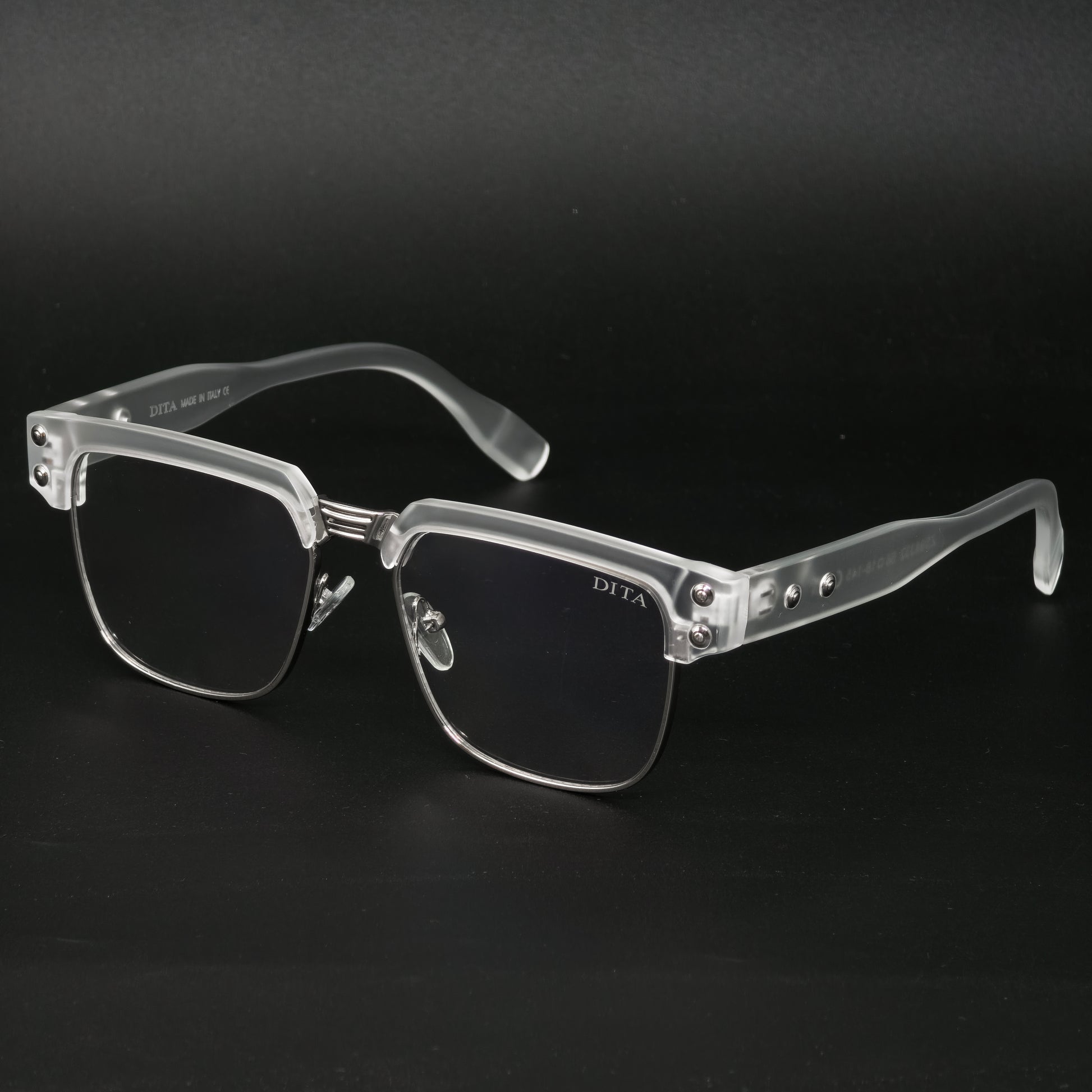 Clear eyeglasses with silver accents on a black background