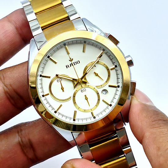 A RADO chronograph watch with a silver and gold-colored case, featuring a white watch face and a steel strap.